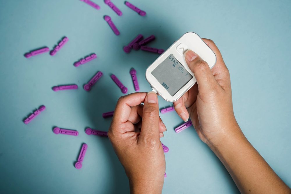 Hands using a glucose meter